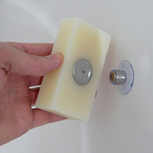 savon blanc posé sur porte savon aimanté dans salle de bain
