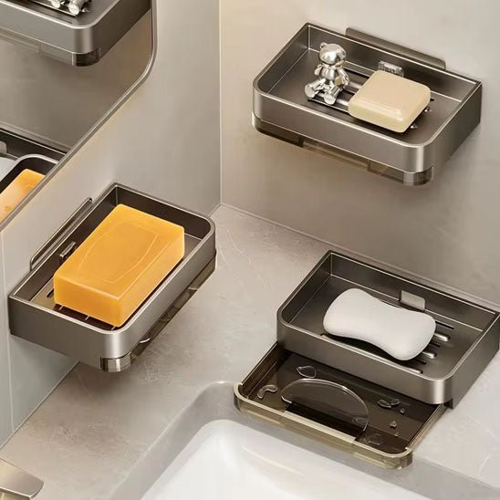 trois porte savon métallique avec barres de savon au-dessus d'un lavabo